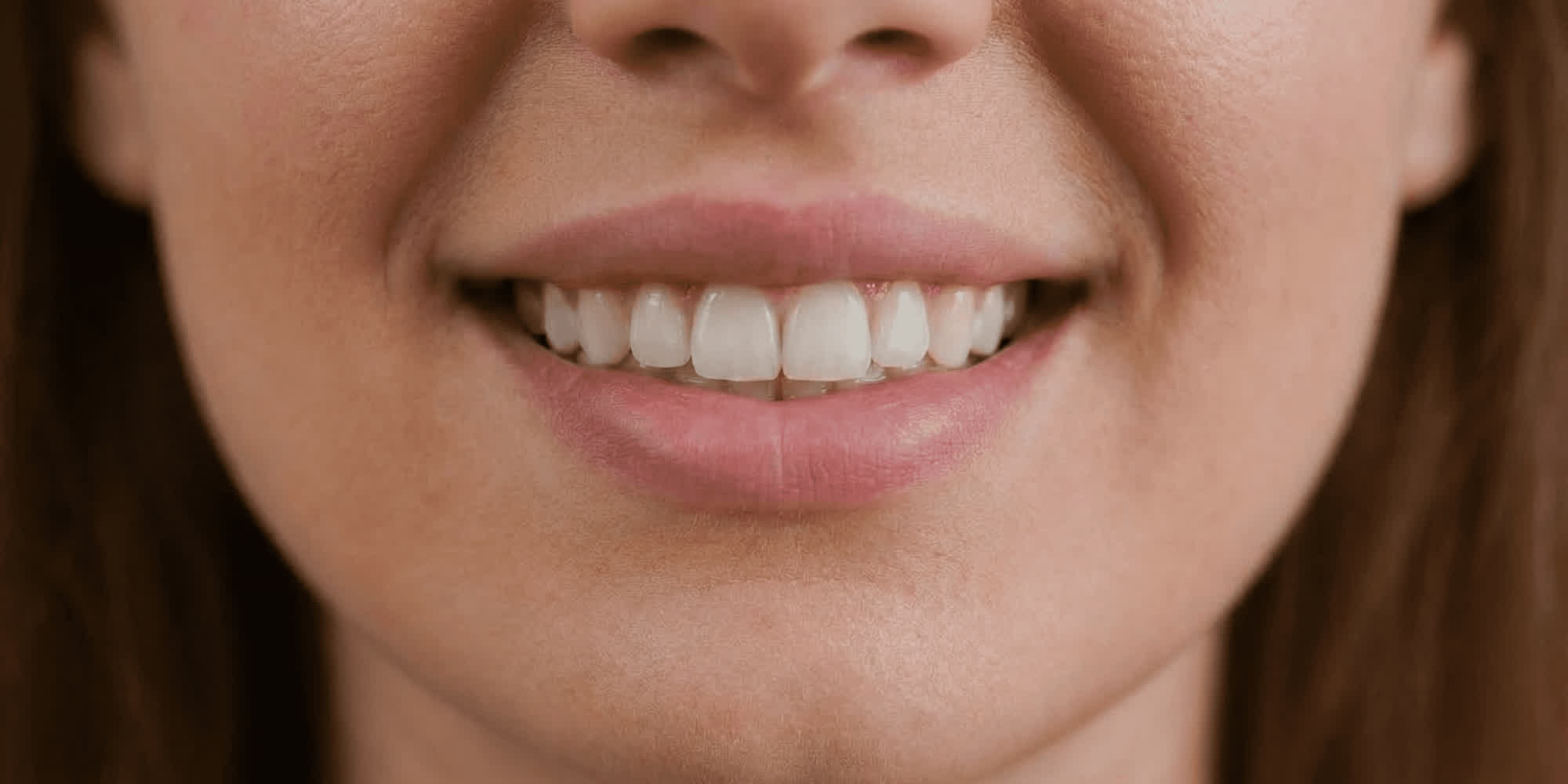 Nahaufnahme einer lächelnden Frau mit sichtbaren Zähnen